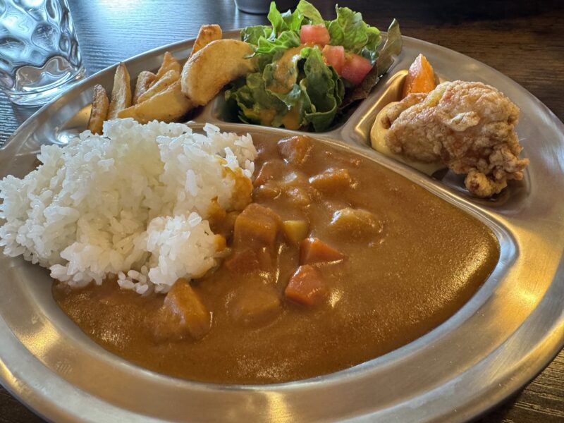 子供向けのキッズプレート。カレー、白いご飯、サラダ、フライドポテト、唐揚げが仕切られたプレートに盛り付けられている