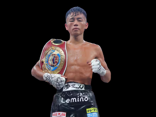 WBO世界バンタム級王者の武居由樹選手が、チャンピオンベルトを肩に掛け、ボクシングのポーズをとっている写真。黒い背景に、汗で濡れた上半身と白いグローブ、「Lemino」のロゴが入った黒いトランクスを着用している姿が映っている。