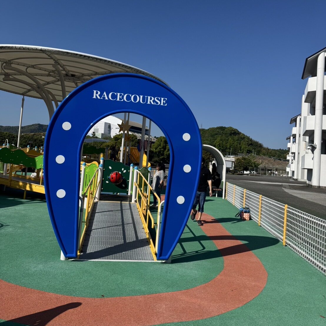 バババパークの蹄鉄型トンネル。青色の馬蹄型アーチに「RACECOURSE」の文字が書かれた競馬場らしいデザインの遊具。幼児用エリアの目印となっている。
