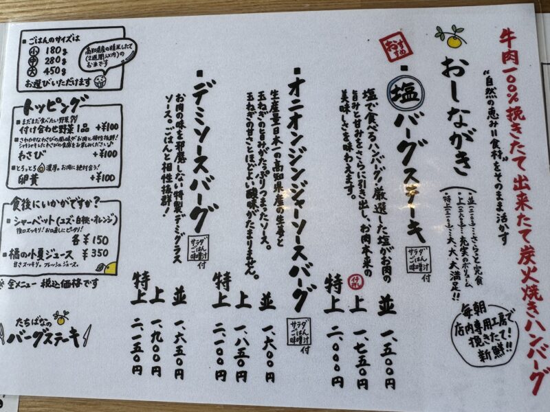 「たちばなのバーグステーキ」のメニュー表。塩バーグステーキ、オニオンジンジャーソースバーグ、デミソースバーグの3種類と、サイズやトッピングの選択肢が記載されている。