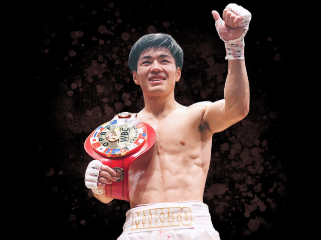 中野幹士選手がOPBF東洋太平洋フェザー級チャンピオンベルトを持ち右手を上げて勝利のポーズを取っている写真