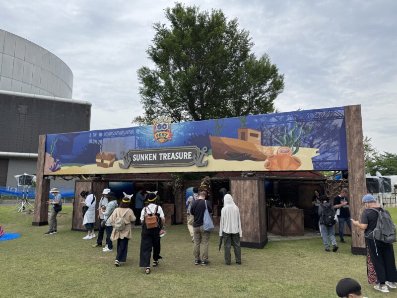 「SUNKEN TREASURE」(海底の秘宝)エリアの装飾ブース。海底をテーマにした青い看板に宝箱や沈没船のイラストが描かれ、木製の海賊船風の構造物が設置されている。多くの参加者が周囲に集まり、ゲームをプレイしている。