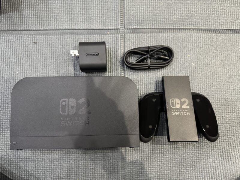 Nintendo Switch 2の付属品一式が並べられた画像。Switch 2ドック、ACアダプター、HDMIケーブル、Joy-Con 2グリップが配置されている